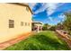 Landscaped backyard featuring a lush lawn, flower beds, covered patio and exterior of the house at 8233 Valley Stream Ave, Las Vegas, NV 89131