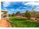 Green backyard with a well-kept lawn, covered patio and partial view of the house at 8233 Valley Stream Ave, Las Vegas, NV 89131