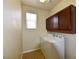 Functional laundry room with washer, dryer, overhead cabinets, and a window for natural light at 8376 Rygate Ave, Las Vegas, NV 89178
