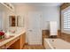 Bathroom features double sink vanity, soaking tub, and tile accent wall at 991 Ridge Path Ave, Henderson, NV 89015