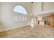 Bright living room with high ceilings, large arched windows, and tile flooring, adjacent to the kitchen at 991 Ridge Path Ave, Henderson, NV 89015