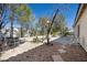 Backyard with gravel, small trees, plants, and a patio seating area at 10808 Aire Dr, Las Vegas, NV 89144