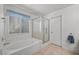 Well-lit bathroom featuring a tub, glass enclosed shower, and tile flooring at 10808 Aire Dr, Las Vegas, NV 89144