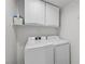 A bright laundry room with a modern washer and dryer and upper cabinets at 10808 Aire Dr, Las Vegas, NV 89144