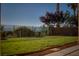Well-manicured backyard with green grass, mature trees, and a view of the mountains at 1219 Diamond Valley St, Henderson, NV 89052