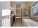 Spacious bathroom with a soaking tub, glass shower enclosure, double sink, and neutral tile at 1219 Diamond Valley St, Henderson, NV 89052