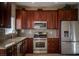 Well-lit kitchen with stainless steel appliances and granite countertops and rich cherry wood cabinets at 1219 Diamond Valley St, Henderson, NV 89052