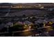 Night shot of a quiet residential street with glowing homes, palm trees, and distant city lights at 1219 Diamond Valley St, Henderson, NV 89052