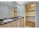Bright bathroom featuring double sinks, granite countertop, and a walk-in closet for ample storage at 20 E Serene Ave # 304, Las Vegas, NV 89123