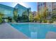 Community pool with lounge chairs surrounded by trees and a glass building at 20 E Serene Ave # 304, Las Vegas, NV 89123