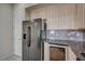Kitchen with stainless steel refrigerator, built-in wine cooler, and wooden cabinets at 20 E Serene Ave # 304, Las Vegas, NV 89123
