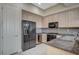 Well-equipped kitchen features wooden cabinets, granite countertops, and modern black appliances at 20 E Serene Ave # 304, Las Vegas, NV 89123
