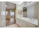 Bright bathroom featuring a double sink vanity with a large mirror and white cabinets at 20 Serene Ave # 201, Las Vegas, NV 89123