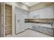 Well-lit kitchen boasts white cabinets, granite counters, tile floors, and pantry at 20 Serene Ave # 201, Las Vegas, NV 89123