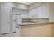 Kitchen featuring granite counters, white cabinets, and stainless steel appliances at 20 Serene Ave # 201, Las Vegas, NV 89123
