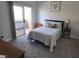 Inviting bedroom with floral bedding, plush carpet, and sliding glass door to balcony at 2052 Jade Creek St # 202, Las Vegas, NV 89117