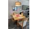 Bright dining area featuring a wooden table set, modern light fixture and grey-toned cabinets at 2052 Jade Creek St # 202, Las Vegas, NV 89117