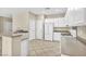A kitchen featuring white cabinets and appliances, complementing the neutral countertops and tile flooring at 2119 Lewiston Pl, Henderson, NV 89044