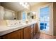 This bathroom includes double sinks with wood cabinets, tiled counters, and a shower and tub combo at 2823 Landau Ct, Henderson, NV 89074