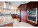 Modern kitchen with granite countertops, stainless steel appliances, and a view to an additional dining area at 2823 Landau Ct, Henderson, NV 89074