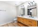 Updated bathroom with dual sinks, modern fixtures, and stylish wood-look tile flooring at 3119 Desmond Ave, Las Vegas, NV 89121