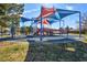 Community playground and swingset surrounded by trees and a soft rubber surface at 3119 Desmond Ave, Las Vegas, NV 89121