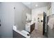 Bright bathroom featuring an open shower, dark wood cabinet, marble countertop and modern fixtures at 3530 S Spring Mountain Blvd Ct, Pahrump, NV 89048
