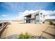 Modern two-story home with a flat roof, a second story balcony and desert landscaping at 3530 S Spring Mountain Blvd Ct, Pahrump, NV 89048