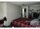 View of the bedroom with a closet and a bed with a red and black plaid comforter at 421 Miller Ave, North Las Vegas, NV 89030