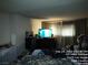 View of the bedroom with a television on a dresser and curtains in the window at 421 Miller Ave, North Las Vegas, NV 89030