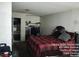 View of the bedroom with a closet and a bed with a red and black plaid comforter at 421 Miller Ave, North Las Vegas, NV 89030