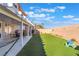 Expansive backyard features an extended covered patio, artificial turf, and a charming desert landscape at 4450 Zev Ct, Las Vegas, NV 89121