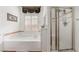 Bright bathroom featuring a soaking tub, separate shower, and window with shutter-style blinds at 4450 Zev Ct, Las Vegas, NV 89121