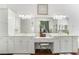 Bathroom vanity with double sinks, decorative mirror, vanity seating, and modern lighting at 4450 Zev Ct, Las Vegas, NV 89121