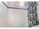 Bathroom with a white tiled shower, blue accents, and an overhead shower curtain rod at 4450 Zev Ct, Las Vegas, NV 89121