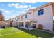 Spacious home featuring a manicured lawn, covered patio with outdoor furniture, and desert landscaping at 4450 Zev Ct, Las Vegas, NV 89121