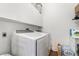 Bright laundry room with white washer and dryer and overhead storage cabinets at 4450 Zev Ct, Las Vegas, NV 89121
