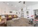 Large living room with brown carpet, brown leather couch, and workout equipment at 4450 Zev Ct, Las Vegas, NV 89121