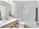 Clean bathroom with a modern vanity, white tiling and shower-tub combo at 4571 Mcmillan Rd, Las Vegas, NV 89121