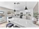 Bright kitchen features white cabinets, marble countertops, stainless steel appliances, and a view of the pool at 4571 Mcmillan Rd, Las Vegas, NV 89121