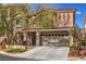 Two-story stucco home with a red tile roof, an attached two-car garage and mature xeriscaped landscaping at 5486 Tartan Hill Ave, Las Vegas, NV 89141