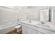 A bright bathroom features a double sink vanity with quartz countertop, subway tile backsplash and wood look floors at 637 N Water St, Henderson, NV 89015