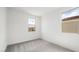 A light-filled bedroom with neutral carpet, white walls and trim, and bright double windows at 637 N Water St, Henderson, NV 89015