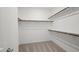 A walk-in closet features neutral carpet, white walls and trim, and wood shelves and rods at 637 N Water St, Henderson, NV 89015