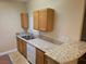 Well lit kitchen features matching cabinetry and granite countertops plus stainless steel dishwasher at 7255 W Sunset Rd # 1171, Las Vegas, NV 89113