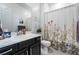 Bright bathroom featuring a vanity with ample storage and a shower with floral curtain at 794 Sunny Sagebrush St, Henderson, NV 89011