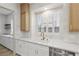 Bright kitchen with quartz counters, white cabinetry and modern fixtures, with shutters on the window at 800 Jody Brook Ct, Las Vegas, NV 89145