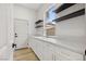 Bright laundry room featuring white cabinetry, marble countertops, a stylish gold faucet and floating shelves at 800 Jody Brook Ct, Las Vegas, NV 89145