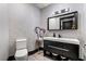Powder room featuring patterned wallpaper, wood flooring, and a dark vanity with a white sink at 9101 Alta Dr # 1206, Las Vegas, NV 89145