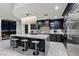 Modern kitchen boasts an island with seating, dark cabinetry, and a stunning chandelier overlooking city views at 9101 Alta Dr # 1206, Las Vegas, NV 89145